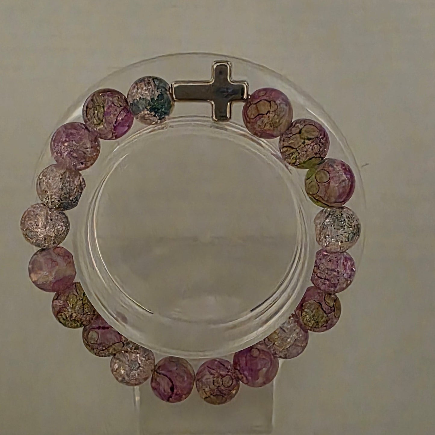 Multicolored beaded bracelet with a cross on a clear background