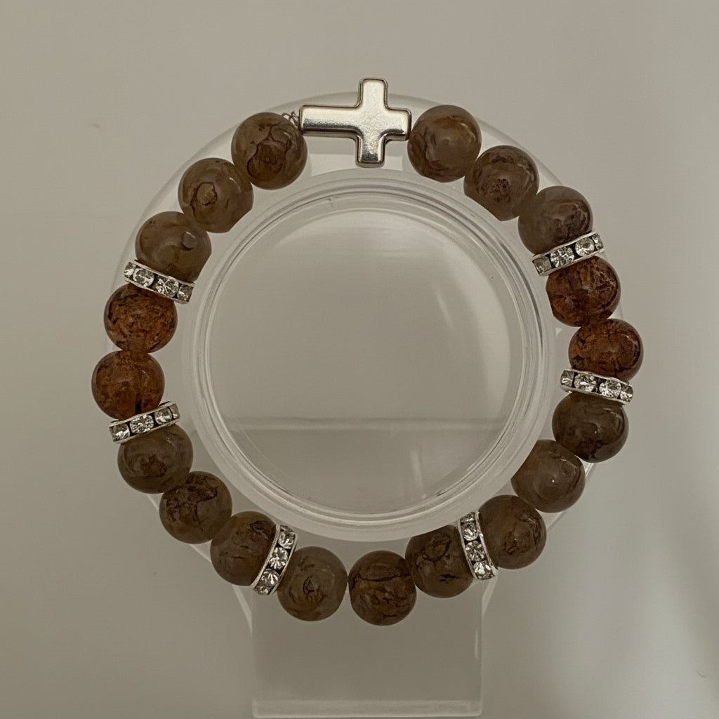 Bracelet with brown beads and a silver cross on a white background