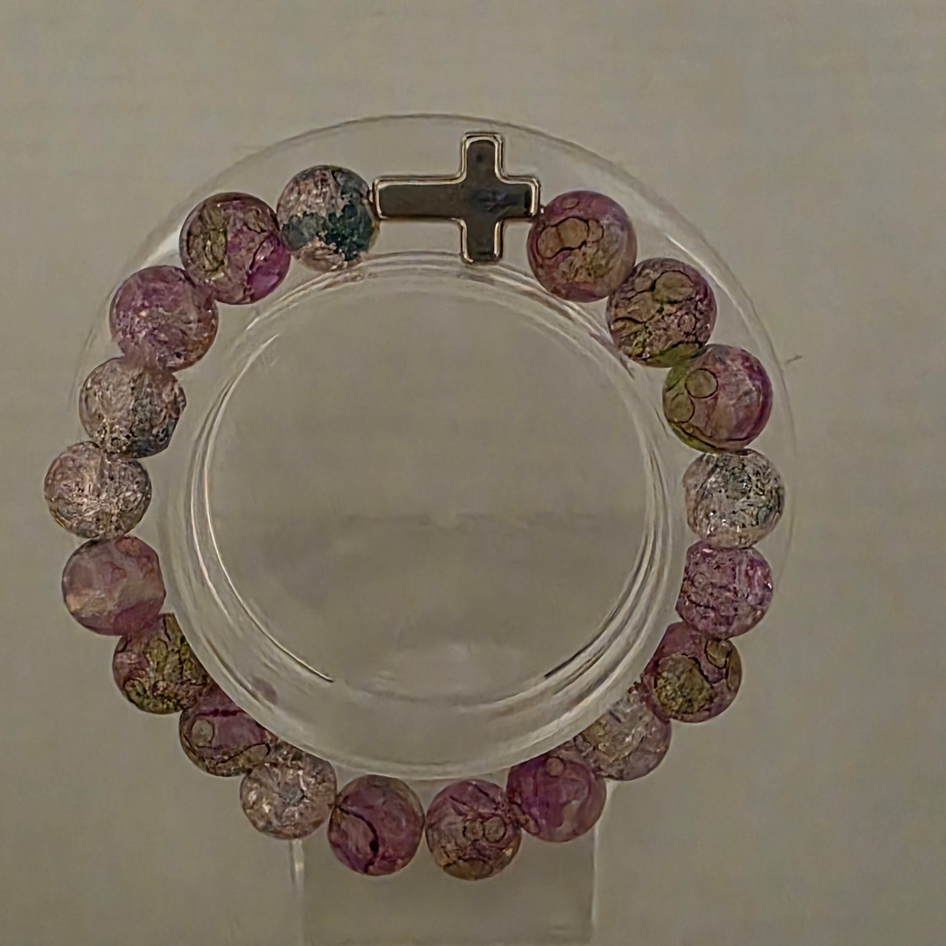Multicolored beaded bracelet with a cross on a clear background